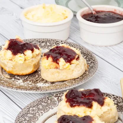 Devon scones topped with clotted cream and strawberry jam